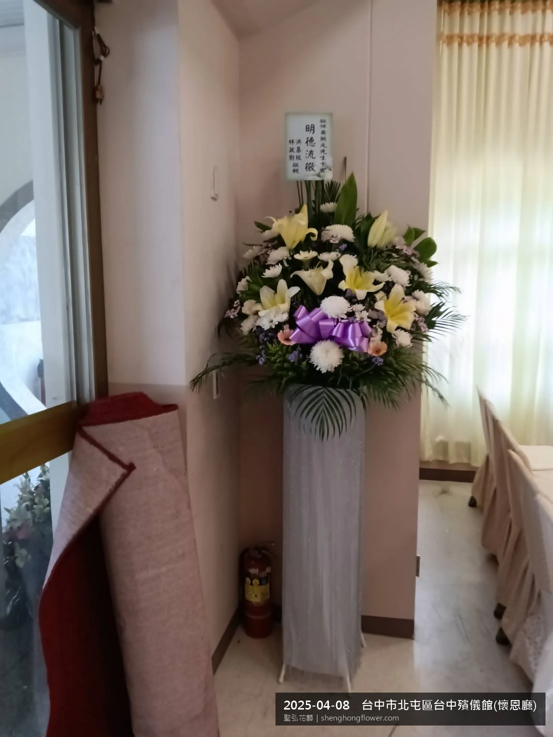 白菊喪禮花籃百合主花配白菊填充、整體素雅，於春末穀雨時節氣候溫暖偏濕花朵保鮮極佳。送達台中北屯台中殯儀館(懷恩廳)前後完成擺設，素雅莊重，寄託家屬哀思敬意，聖弘花藝在地團隊現場實拍照。
