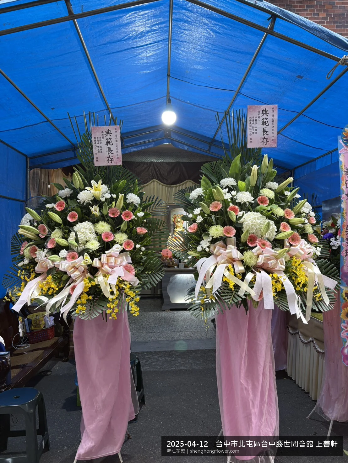 春末穀雨時節氣候溫暖偏濕下，台中北屯台中勝世間會館 上善住家靈堂前光線柔和。我們選用高架白菊花籃，雙劍蘭挑高、黃菊鋪底，現場顯得沉靜典雅，誠摯傳達對家屬的關懷。