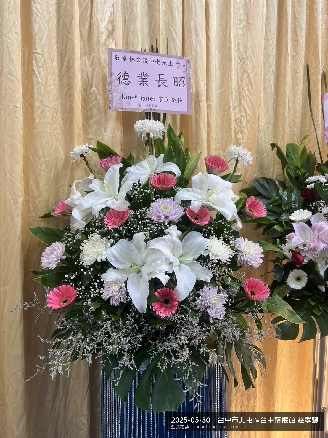 初夏暖陽氣候宜人下，台中北屯台中殯儀館 慈孝聽前光線柔和。我們選用高架白菊花籃，雙劍蘭挑高、黃菊鋪底，現場顯得沉靜典雅，誠摯傳達對家屬的關懷，聖弘花藝在地團隊現場實拍照。