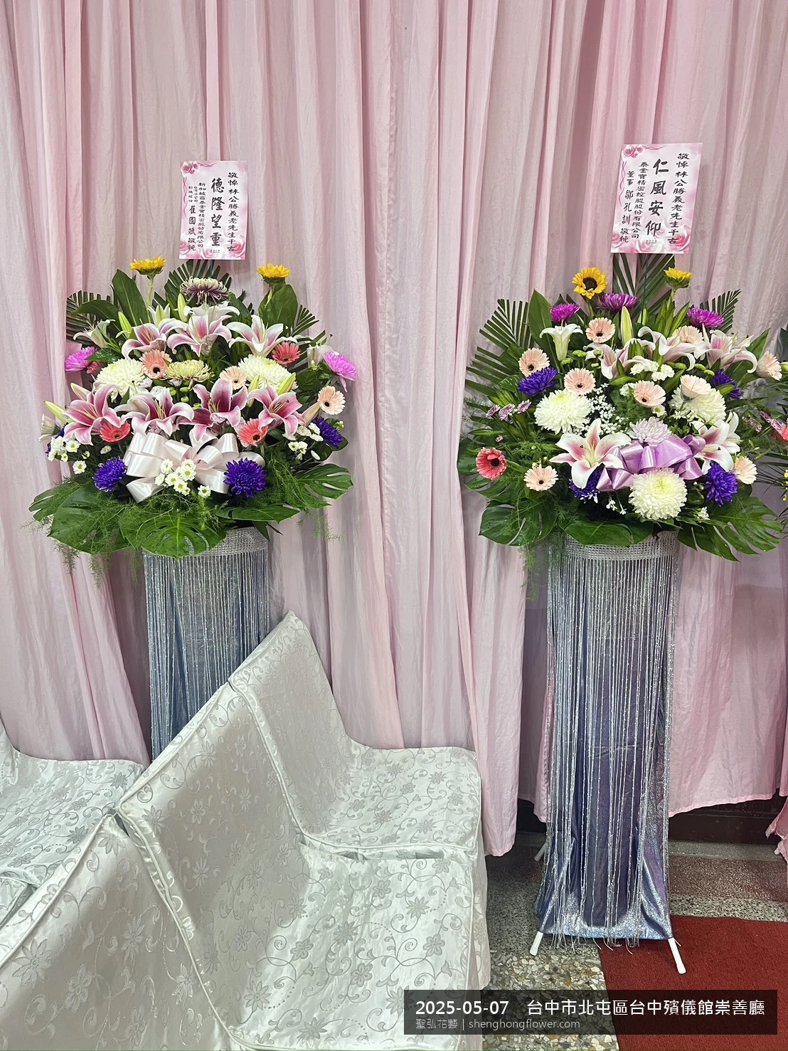 高架白菊花籃主花百合配劍蘭、底部黃菊填充，於初夏暖陽氣候宜人花朵保鮮極佳。送達台中北屯台中殯儀館崇善廳前後完成擺設，沉靜典雅，寄託家屬哀思敬意，聖弘花藝在地團隊現場實拍照。