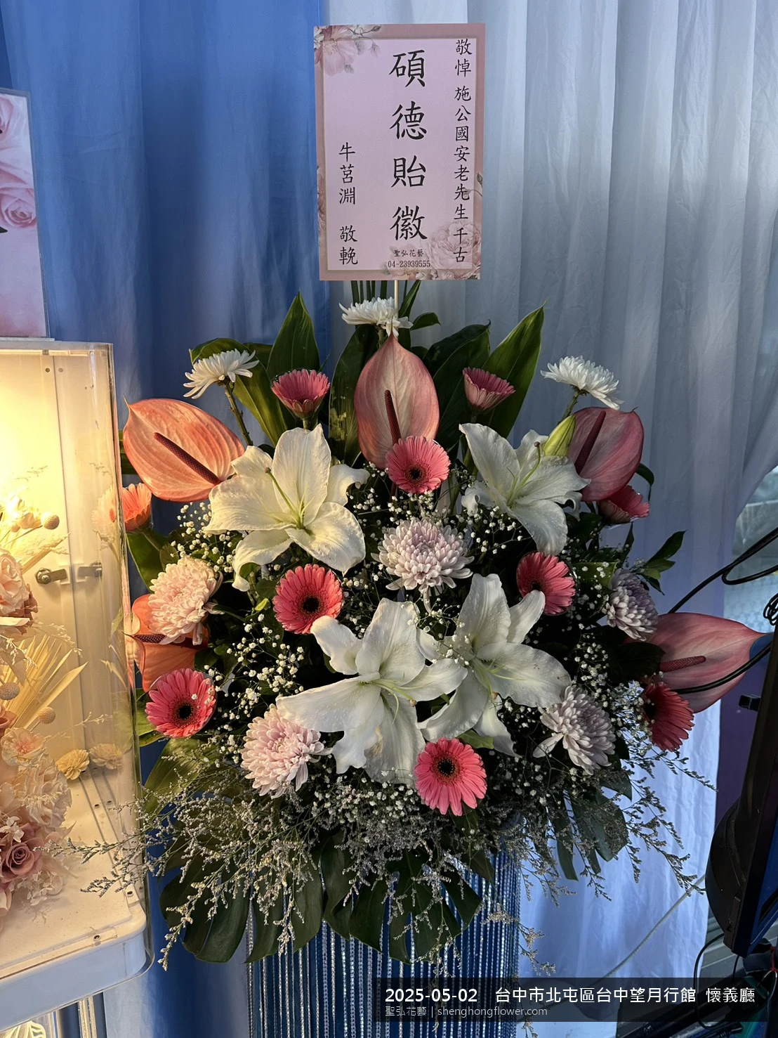 高架白菊花籃主花百合配劍蘭、底部黃菊填充，於初夏暖陽氣候宜人花朵保鮮極佳。送達台中北屯台中望月行館  懷義住家靈堂前後完成擺設，寧靜哀思，寄託家屬哀思敬意，聖弘花藝在地團隊現場實拍照。