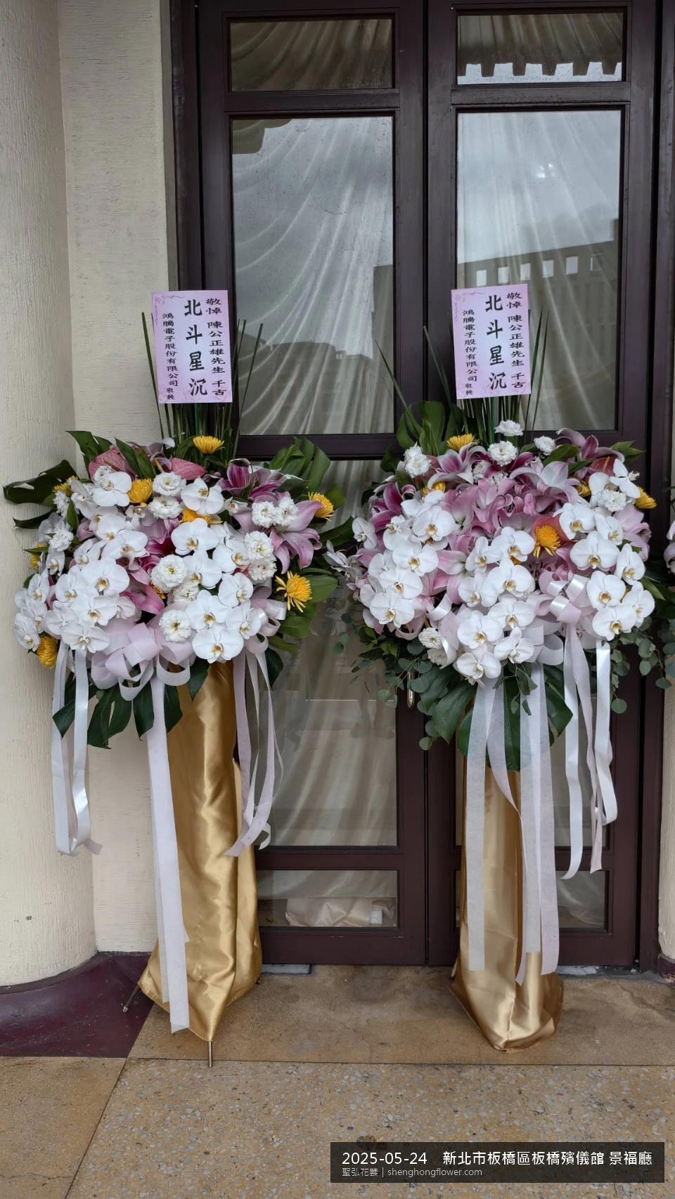 高架白菊花籃主花百合配劍蘭、底部黃菊填充，於初夏暖陽氣候宜人花朵保鮮極佳。送達新北板橋板橋殯儀館 景福廳前後完成擺設，現場端正，於現場完成定位，聖弘花藝在地團隊現場實拍照。