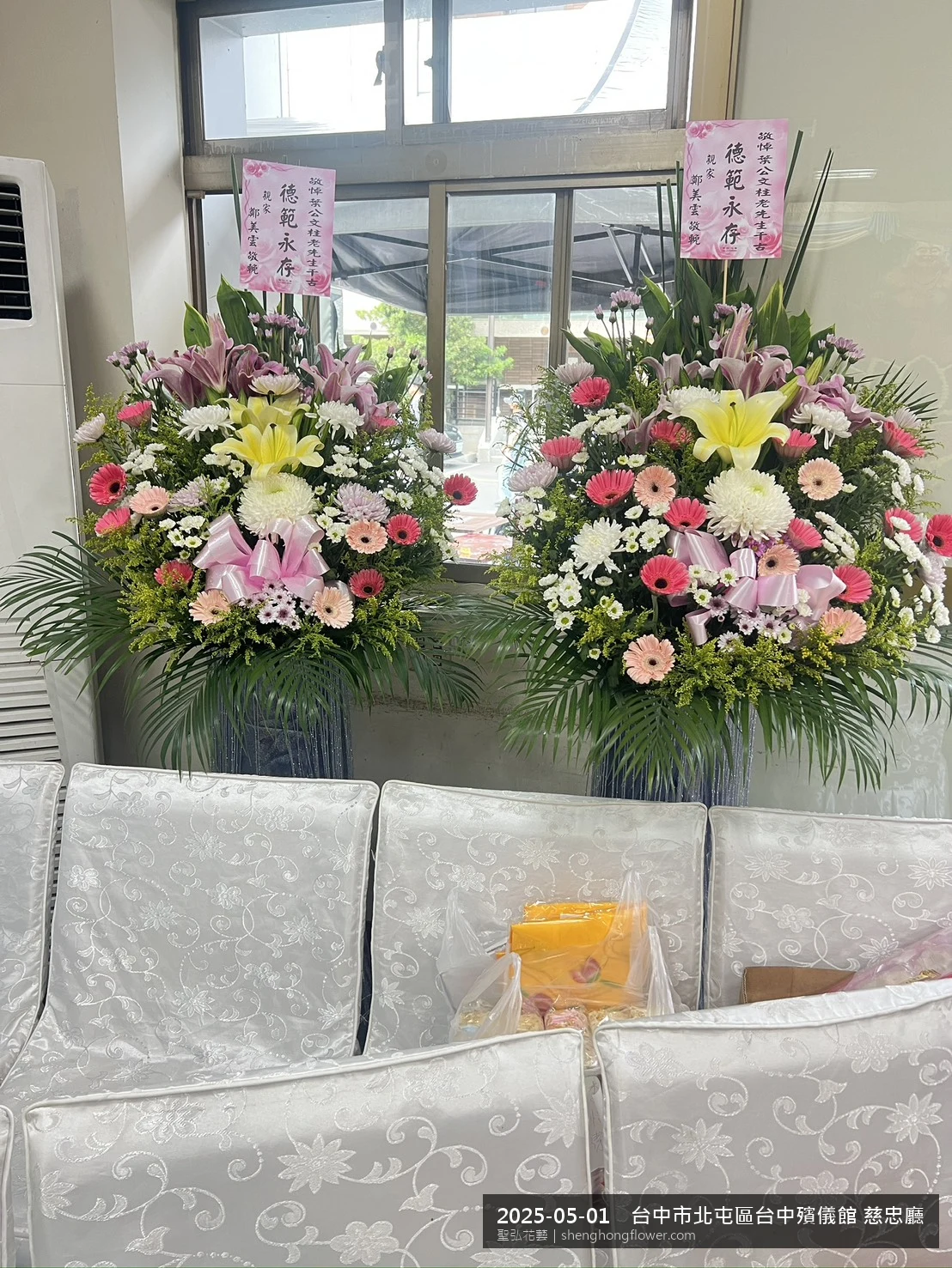 初夏暖陽氣候宜人下高架白菊花籃並陳，雙層花籃結構、上層紅玫瑰下層白菊，送達台中北屯台中殯儀館 慈忠廳前後整體沉靜典雅，傳達家屬最後敬意，聖弘花藝在地團隊現場實拍照。