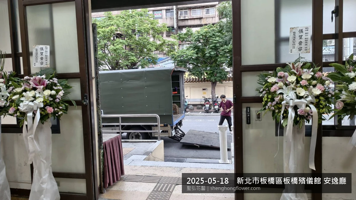 高架白菊花籃主花百合配劍蘭、底部黃菊填充，於初夏暖陽氣候宜人花朵保鮮極佳。送達新北板橋板橋殯儀館 安逸廳前後完成擺設，陳設整齊，依指定方位整齊就位，聖弘花藝在地團隊現場實拍照。