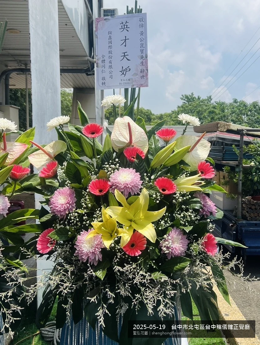 台中北屯台中殯儀館正覺廳前氣氛沉靜典雅，選用高架白菊花籃並高架支架對稱、白菊圍裙裝飾，搭配初夏暖陽氣候宜人的場景，撫慰家屬不捨之情，聖弘花藝在地團隊現場實拍照。