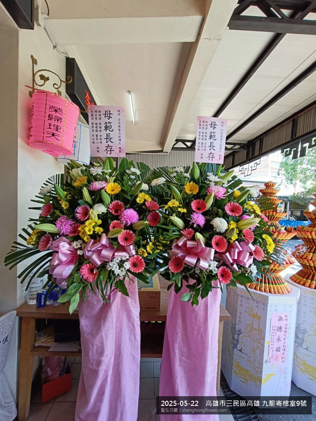 高架白菊花籃主花百合配劍蘭、底部黃菊填充，於初夏暖陽氣候宜人花朵保鮮極佳。送達高雄三民高雄 九龍寄棺室現場後完成擺設，配置妥當，依指定方位整齊就位，聖弘花藝在地團隊現場實拍照。