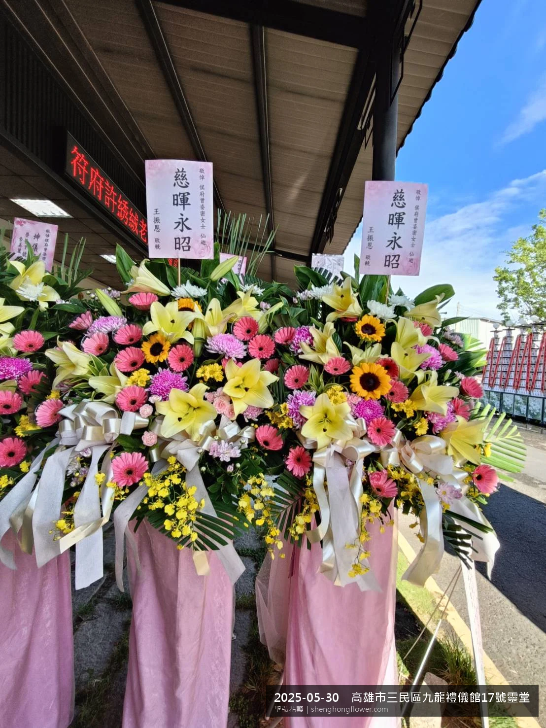 初夏暖陽氣候宜人下高架白菊花籃並陳，雙層花籃結構、上層紅玫瑰下層白菊，送達高雄三民九龍禮儀館靈堂現場後整體整潔有序，依指定方位整齊就位，聖弘花藝在地團隊現場實拍照。