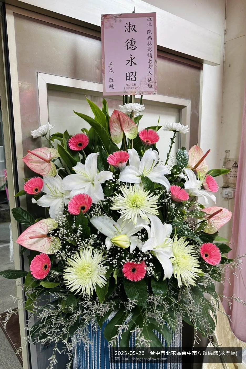 高架白菊花籃主花百合配劍蘭、底部黃菊填充，於初夏暖陽氣候宜人花朵保鮮極佳。送達台中北屯台中市立殯儀館(永樂前後完成擺設，素雅莊重，寄託家屬哀思敬意，聖弘花藝在地團隊現場實拍照。
