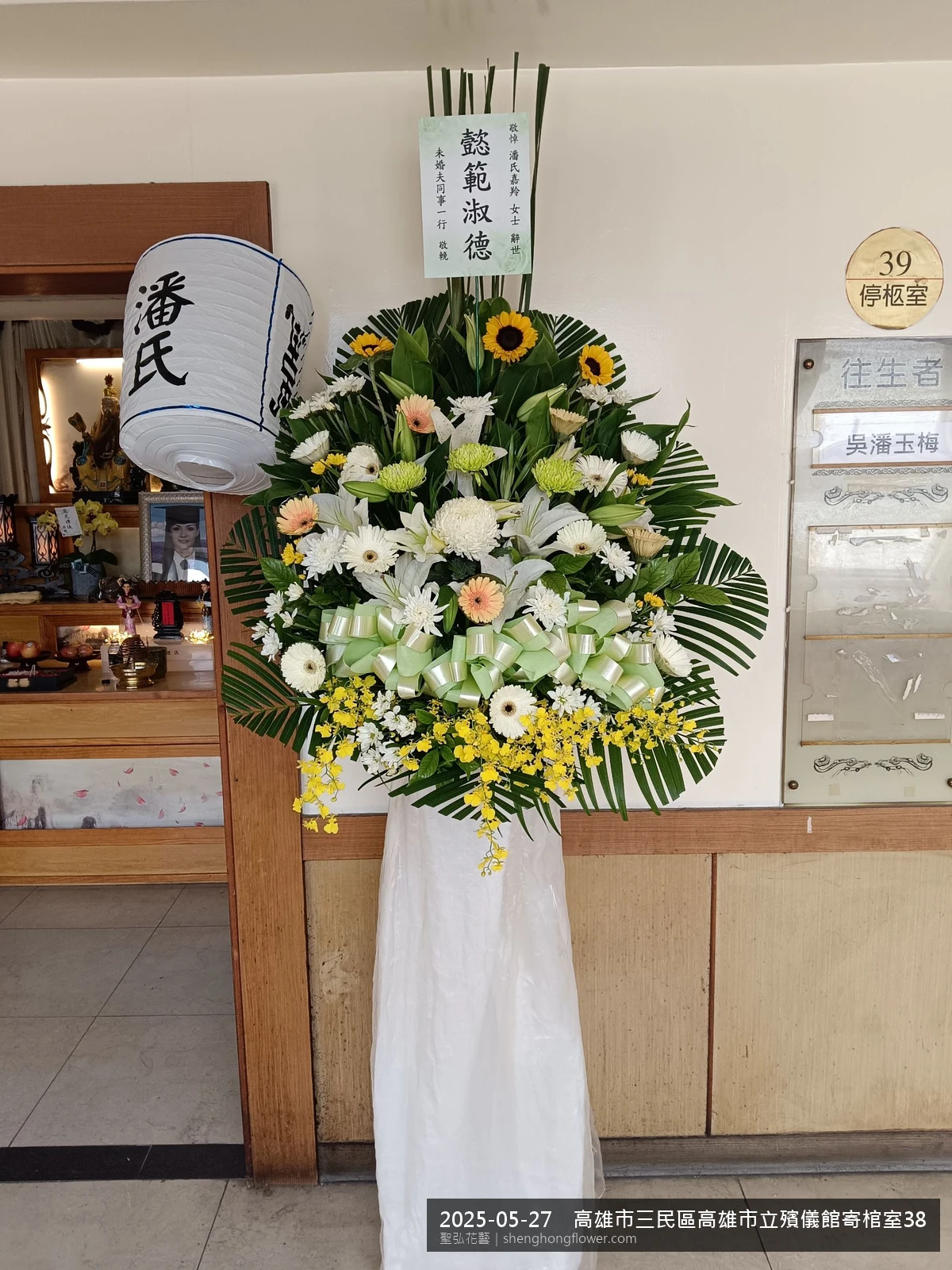 高雄三民高雄市立殯儀館寄棺室靈堂前氣氛陳設整齊，選用高架白菊花籃並高架支架對稱、白菊圍裙裝飾，搭配初夏暖陽氣候宜人的場景，依指定方位整齊就位，聖弘花藝在地團隊現場實拍照。