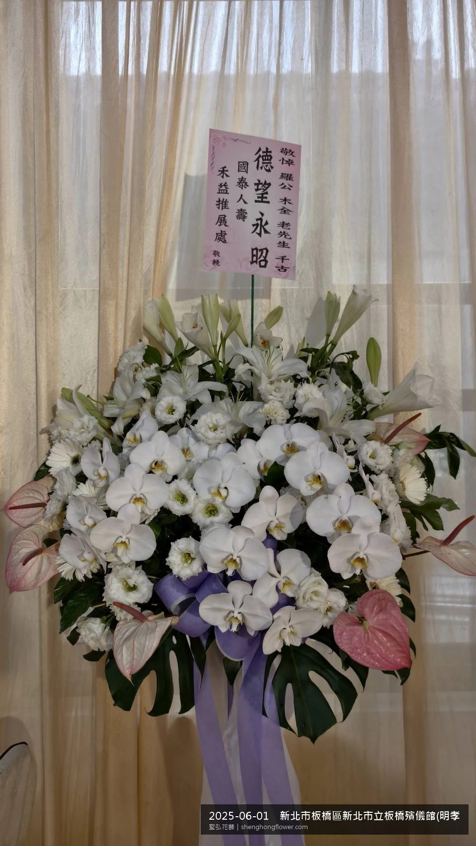 新北板橋新北市立板橋殯儀館(明孝廳)前置高架白菊花籃，氛圍陳設整齊。挑高花架穩固、字牌方向清晰，於盛夏午後氣候炎熱就位完成，於現場完成定位，聖弘花藝在地團隊現場實拍照。