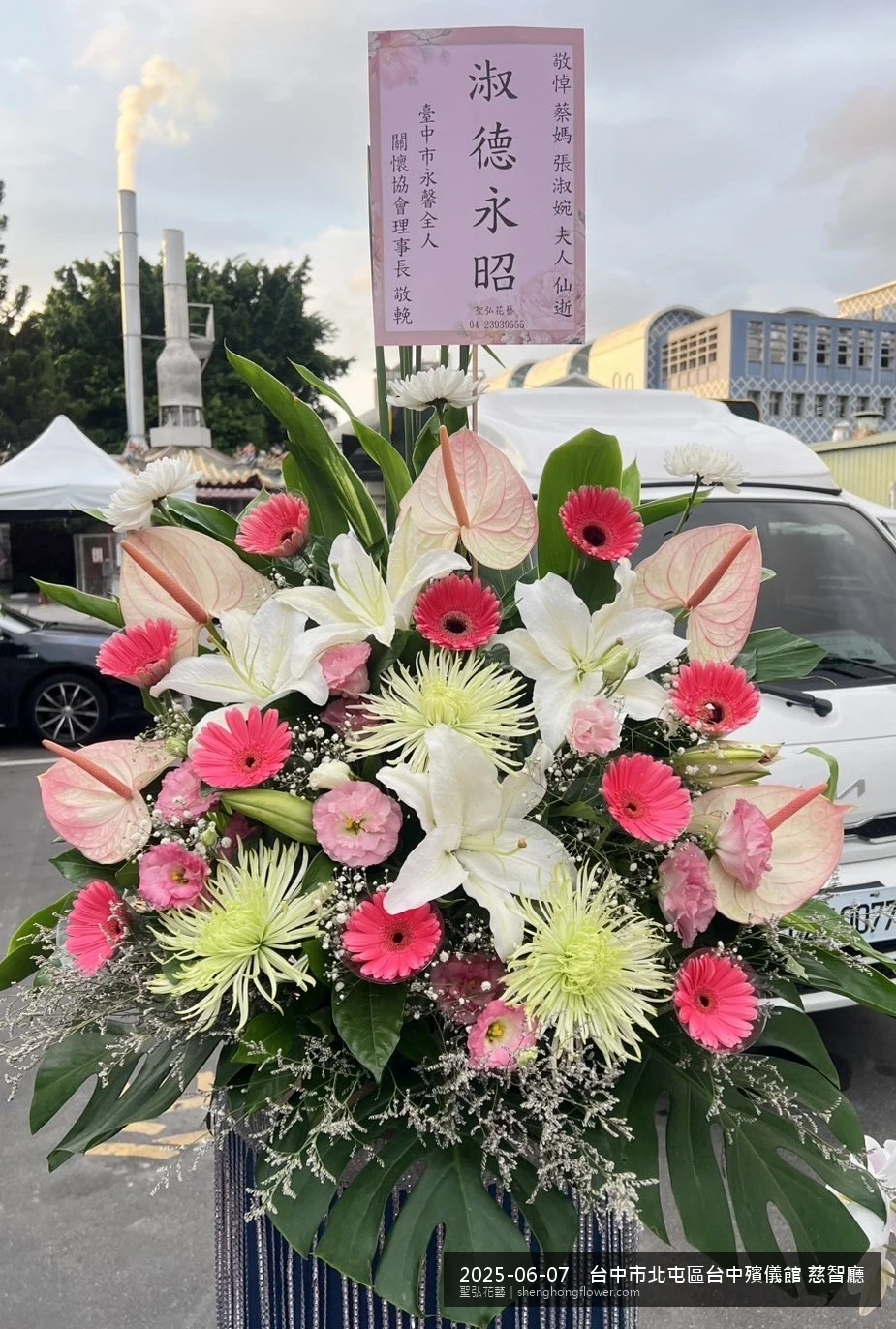 高架白菊花籃主花百合配劍蘭、底部黃菊填充，於盛夏午後氣候炎熱花朵保鮮極佳。送達台中北屯台中殯儀館 慈智廳前後完成擺設，莊嚴端莊，寄託家屬哀思敬意，聖弘花藝在地團隊現場實拍照。