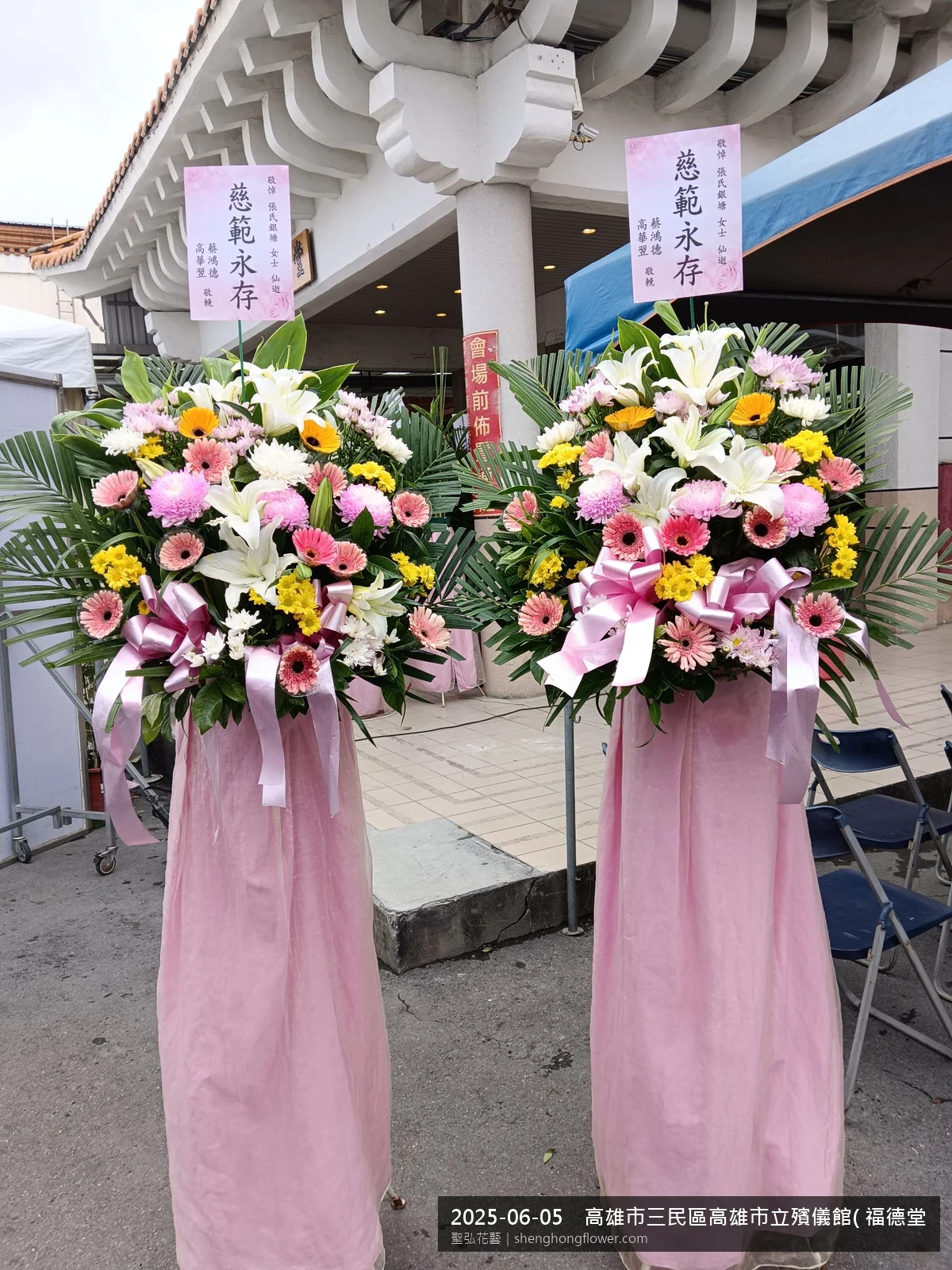 盛夏午後氣候炎熱下，高雄三民高雄市立殯儀館( 福德堂)前光線柔和。我們選用高架白菊花籃，雙劍蘭挑高、黃菊鋪底，現場顯得配置妥當，依指定方位整齊就位，聖弘花藝在地團隊現場實拍照。