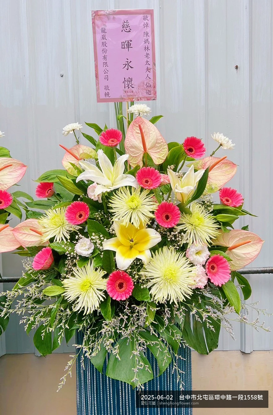 高架白菊花籃主花百合配劍蘭、底部黃菊填充，於盛夏午後氣候炎熱花朵保鮮極佳。送達台中北屯環中路住家靈堂前後完成擺設，肅穆典雅，寄託家屬哀思敬意，聖弘花藝在地團隊現場實拍照。