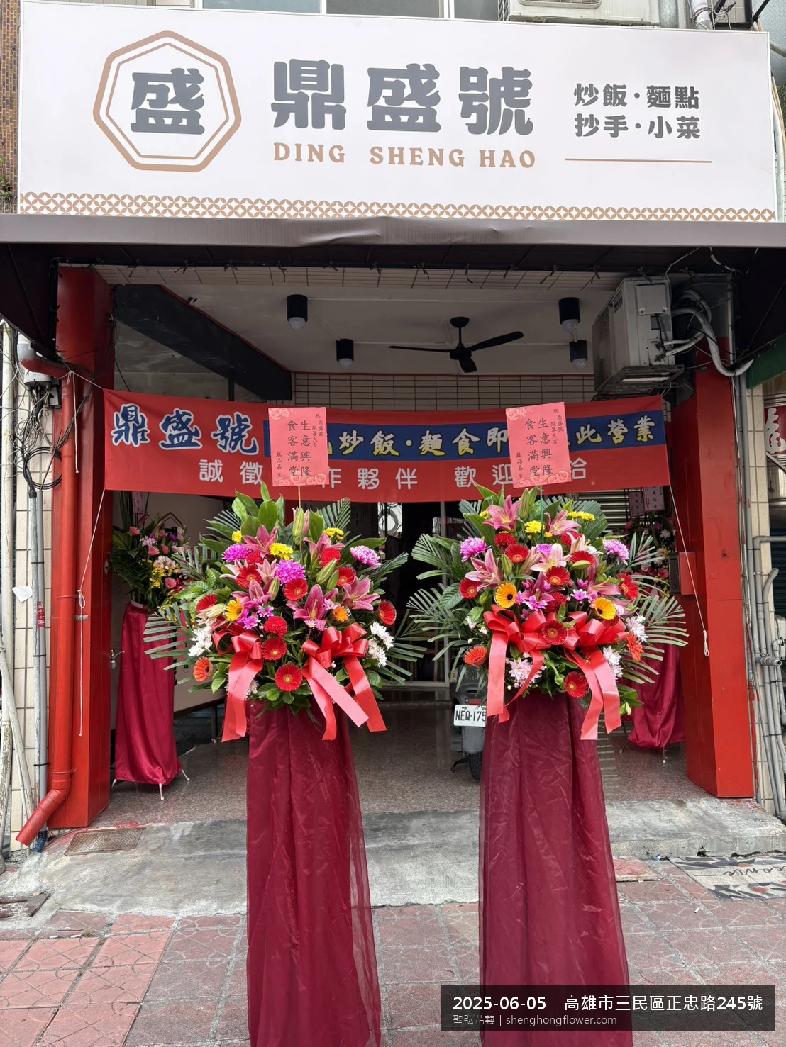 盛夏午後氣候炎熱下高架白菊花籃並陳，雙層花籃結構、上層紅玫瑰下層白菊，送達高雄三民高雄市三民區正忠路現場後整體陳設整齊，於現場完成定位，聖弘花藝在地團隊現場實拍照。