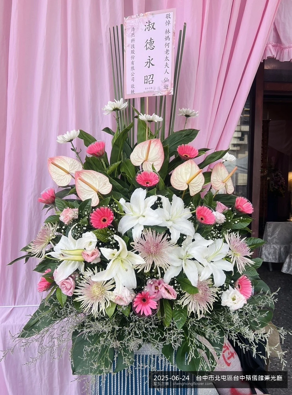 盛夏午後氣候炎熱下高架白菊花籃並陳，雙層花籃結構、上層紅玫瑰下層白菊，送達台中北屯台中殯儀館崇光廳前後整體安寧整齊，傳達家屬最後敬意，聖弘花藝在地團隊現場實拍照。