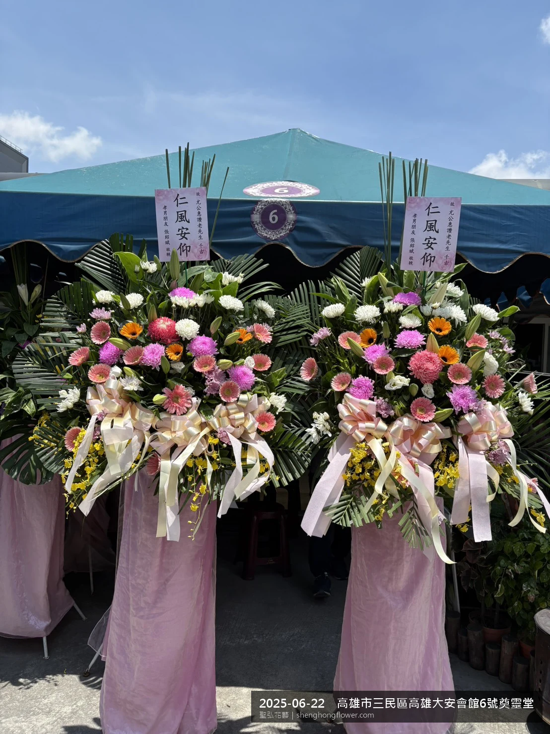 高雄三民高雄大安會館奠靈堂現場置高架白菊花籃，氛圍現場端正。挑高花架穩固、字牌方向清晰，於盛夏午後氣候炎熱就位完成，於現場完成定位，聖弘花藝在地團隊現場實拍照。