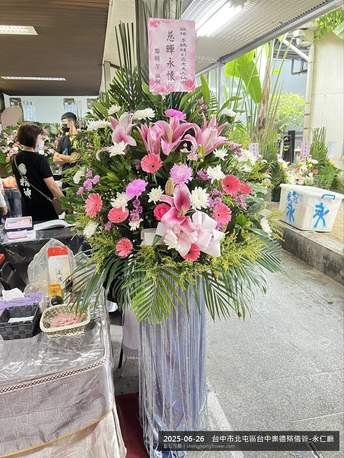 高架白菊花籃主花百合配劍蘭、底部黃菊填充，於盛夏午後氣候炎熱花朵保鮮極佳。送達台中北屯台中崇德殯儀管-永仁住家靈堂前後完成擺設，肅穆典雅，寄託家屬哀思敬意，聖弘花藝在地團隊現場實拍照。