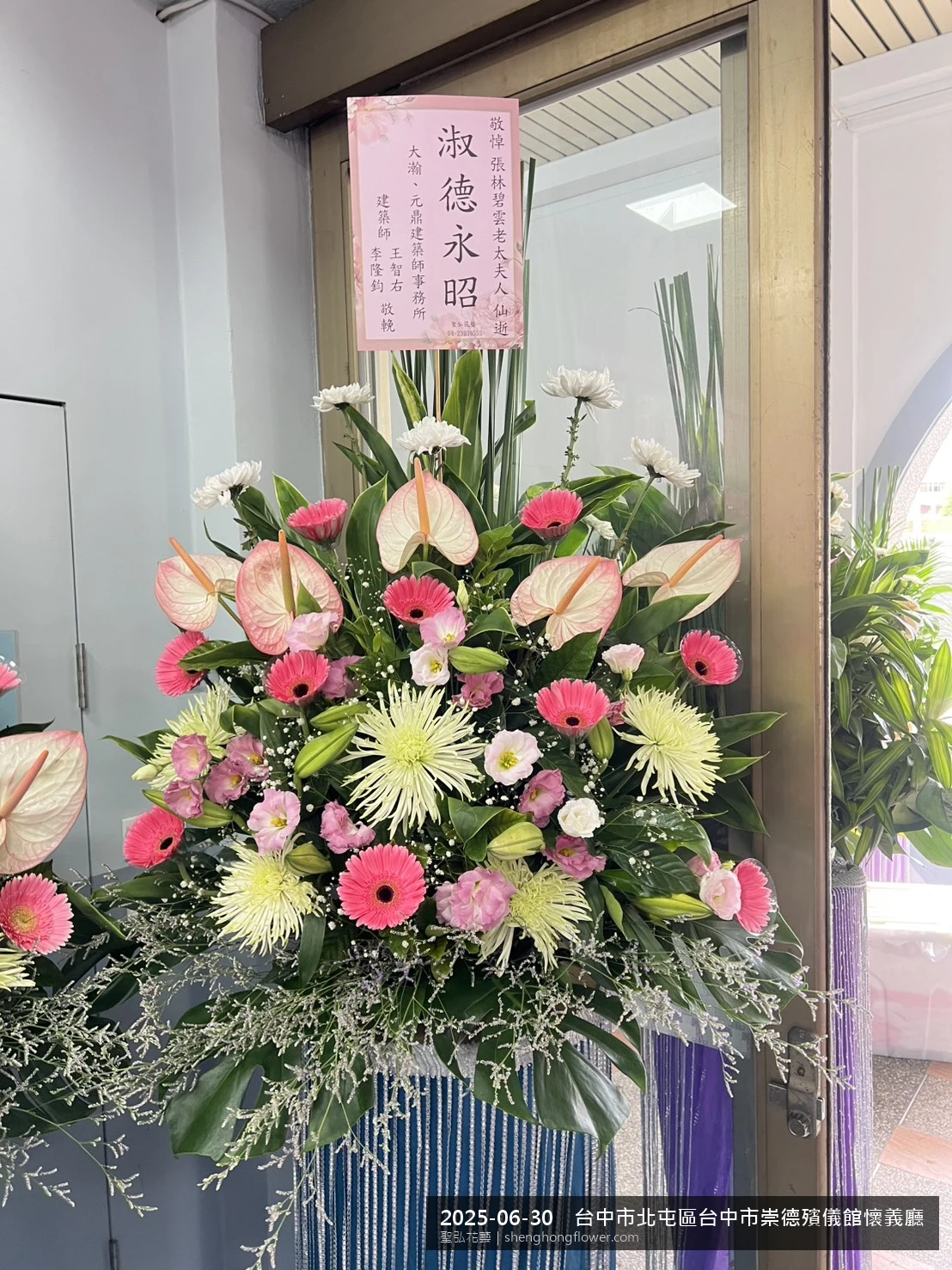 盛夏午後氣候炎熱下，台中北屯台中市崇德殯儀館懷義廳前光線柔和。我們選用白菊喪禮花籃，白菊鋪底、劍蘭立挺，現場顯得沉靜典雅，誠摯傳達對家屬的關懷，聖弘花藝在地團隊現場實拍照。