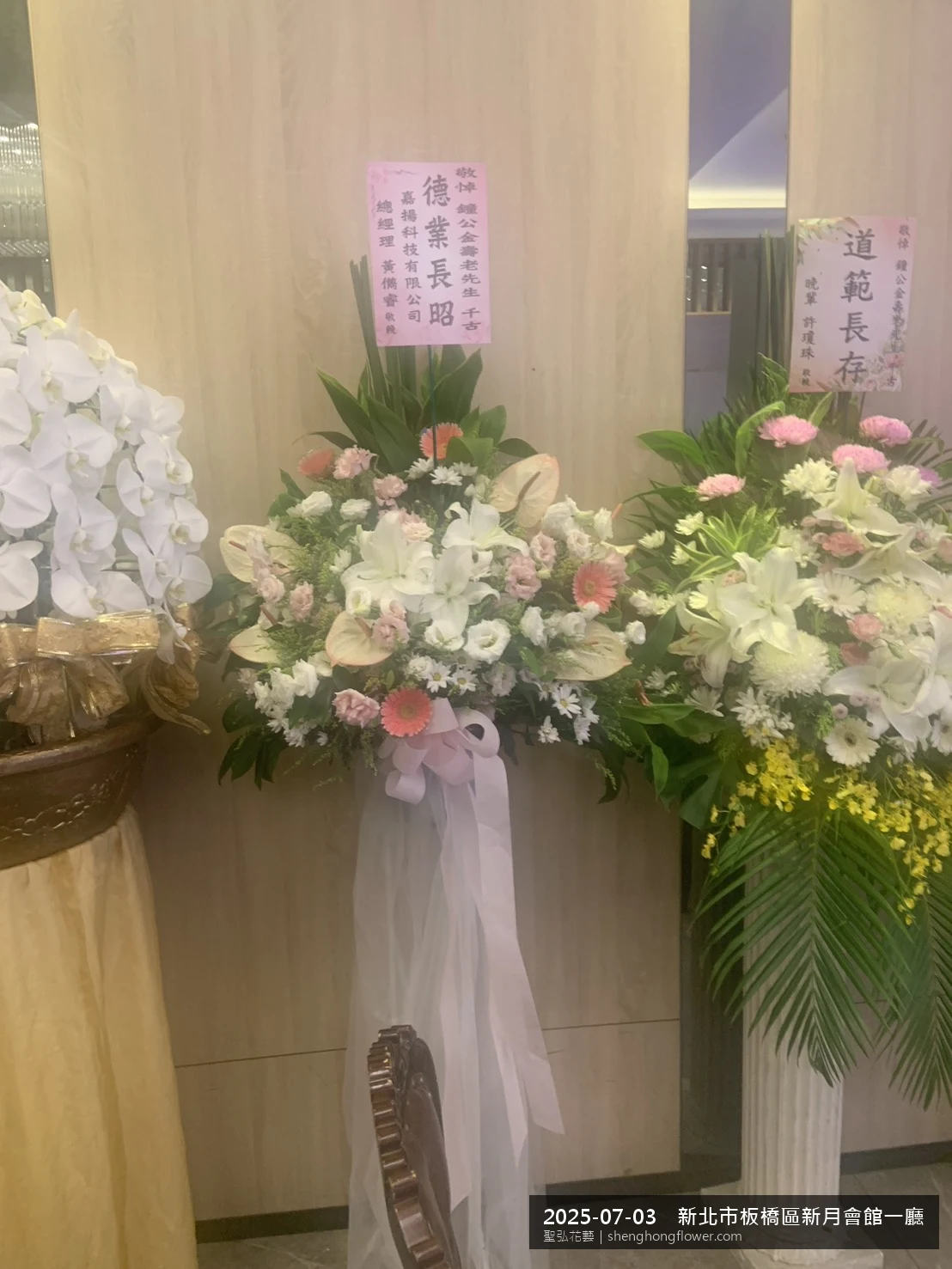 高架白菊花籃主花百合配劍蘭、底部黃菊填充，於盛夏陽光氣候悶熱花朵保鮮極佳。送達新北板橋新月會館一廳現場後完成擺設，整潔有序，依指定方位整齊就位，聖弘花藝在地團隊現場實拍照。