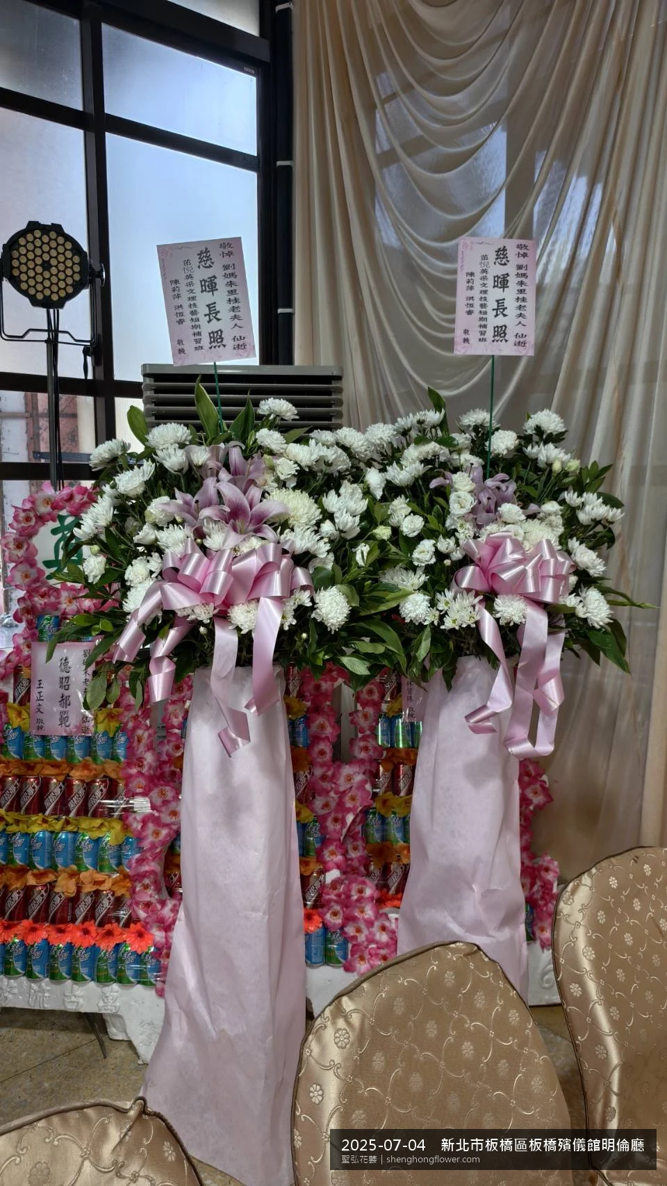新北板橋板橋殯儀館明倫廳前氣氛陳設整齊，選用高架白菊花籃並高架支架對稱、白菊圍裙裝飾，搭配盛夏陽光氣候悶熱的場景，配合主人家完成擺設，聖弘花藝在地團隊現場實拍照。