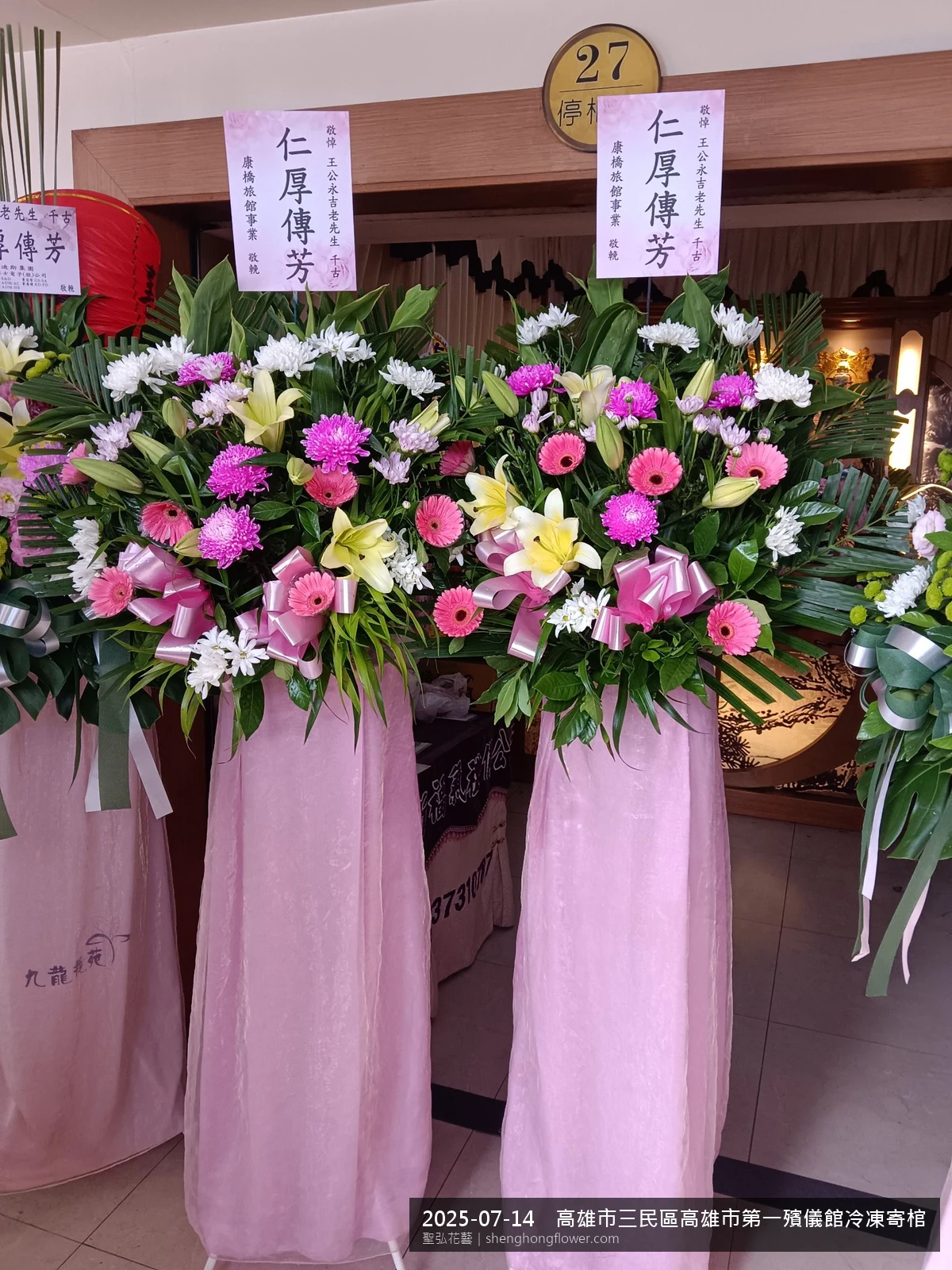 高雄三民高雄市第一殯儀館冷凍寄棺大樓寄棺室前置高架白菊花籃，氛圍整潔有序。挑高花架穩固、字牌方向清晰，於盛夏陽光氣候悶熱就位完成，依指定方位整齊就位，聖弘花藝在地團隊現場實拍照。