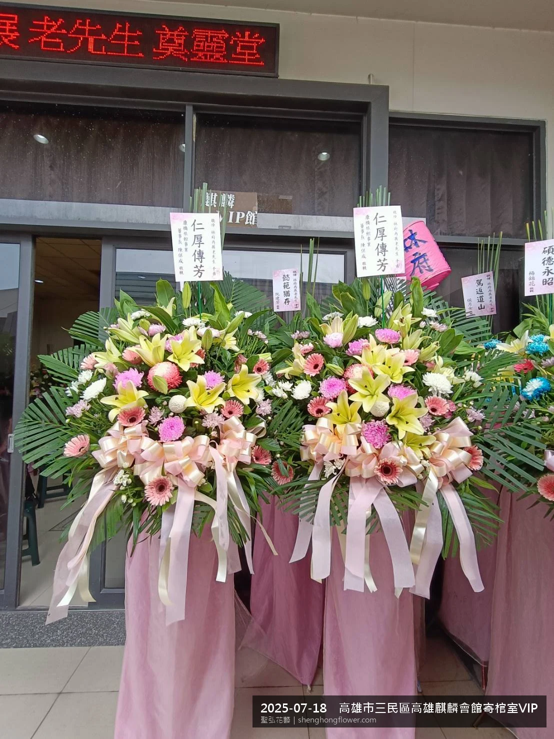 高架白菊花籃主花百合配劍蘭、底部黃菊填充，於盛夏陽光氣候悶熱花朵保鮮極佳。送達高雄三民高雄麒麟會館寄棺室VIP現場後完成擺設，現場端正，於現場完成定位，聖弘花藝在地團隊現場實拍照。