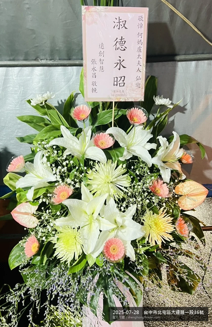 台中北屯大連路住家靈堂前置高架白菊花籃，氛圍寧靜哀思。挑高花架穩固、字牌方向清晰，於盛夏陽光氣候悶熱就位完成，陪伴家屬度過難捨時刻，聖弘花藝在地團隊現場實拍照。
