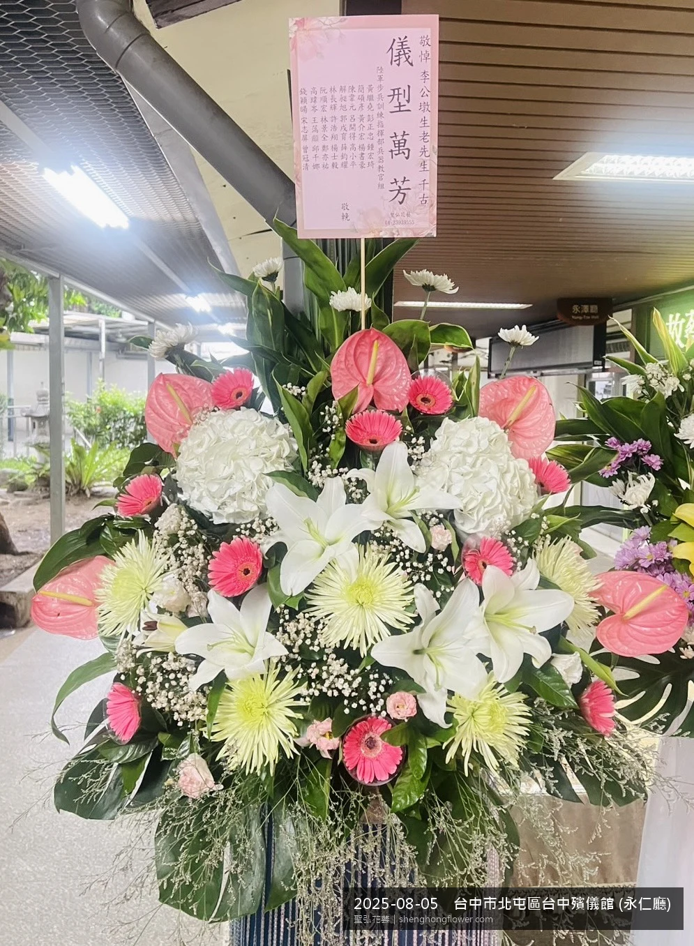 高架白菊花籃主花百合配劍蘭、底部黃菊填充，於夏末暑熱氣候漸轉花朵保鮮極佳。送達台中北屯台中殯儀館 (永仁廳前後完成擺設，肅穆典雅，寄託家屬哀思敬意，聖弘花藝在地團隊現場實拍照。