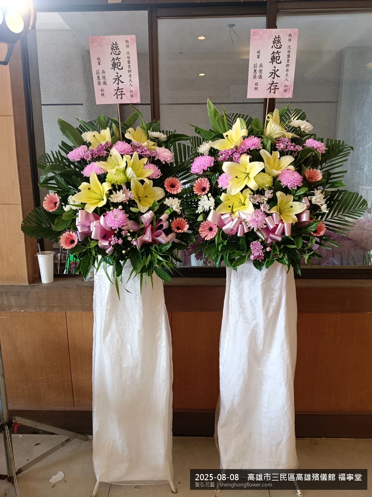 高架白菊花籃主花百合配劍蘭、底部黃菊填充，於夏末暑熱氣候漸轉花朵保鮮極佳。送達高雄三民高雄殯儀館 福寧堂前後完成擺設，配置妥當，配合主人家完成擺設，聖弘花藝在地團隊現場實拍照。