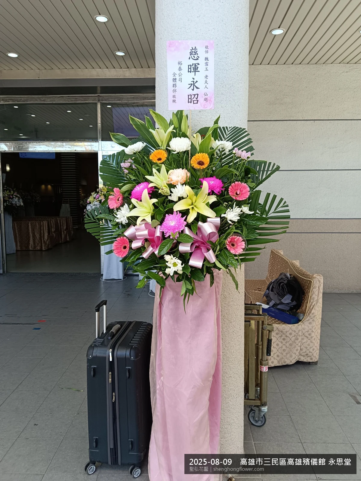 高雄三民高雄殯儀館 永思堂前氣氛整潔有序，選用高架白菊花籃並高架支架對稱、白菊圍裙裝飾，搭配夏末暑熱氣候漸轉的場景，於現場完成定位，聖弘花藝在地團隊現場實拍照。