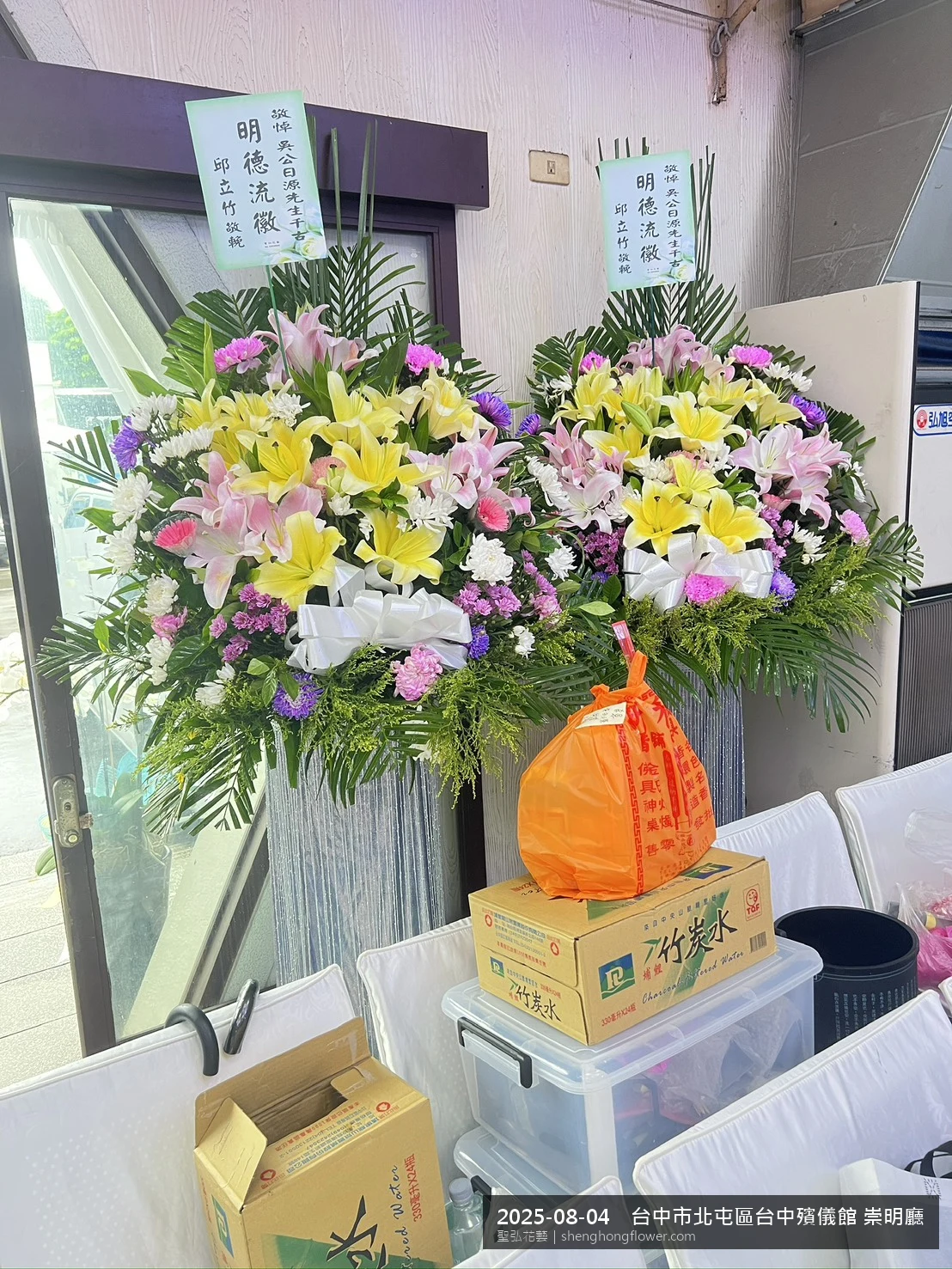 夏末暑熱氣候漸轉下高架白菊花籃並陳，雙層花籃結構、上層紅玫瑰下層白菊，送達台中北屯台中殯儀館 崇明廳前後整體莊嚴端莊，傳達家屬最後敬意，聖弘花藝在地團隊現場實拍照。
