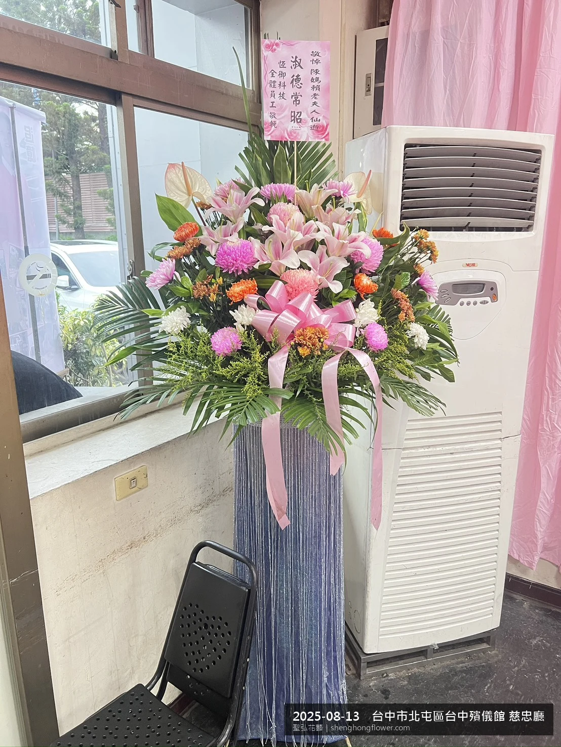 夏末暑熱氣候漸轉下，台中北屯台中殯儀館 慈忠廳前光線柔和。我們選用高架白菊花籃，雙劍蘭挑高、黃菊鋪底，現場顯得安寧整齊，誠摯傳達對家屬的關懷，聖弘花藝在地團隊現場實拍照。