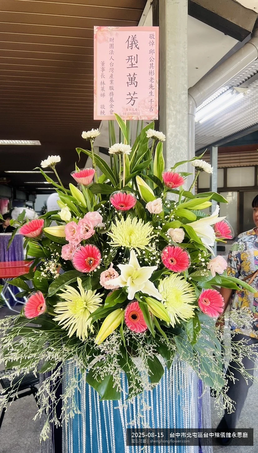 夏末暑熱氣候漸轉下高架白菊花籃並陳，雙層花籃結構、上層紅玫瑰下層白菊，送達台中北屯台中殯儀館永思廳前後整體配置妥當，於現場完成定位，聖弘花藝在地團隊現場實拍照。
