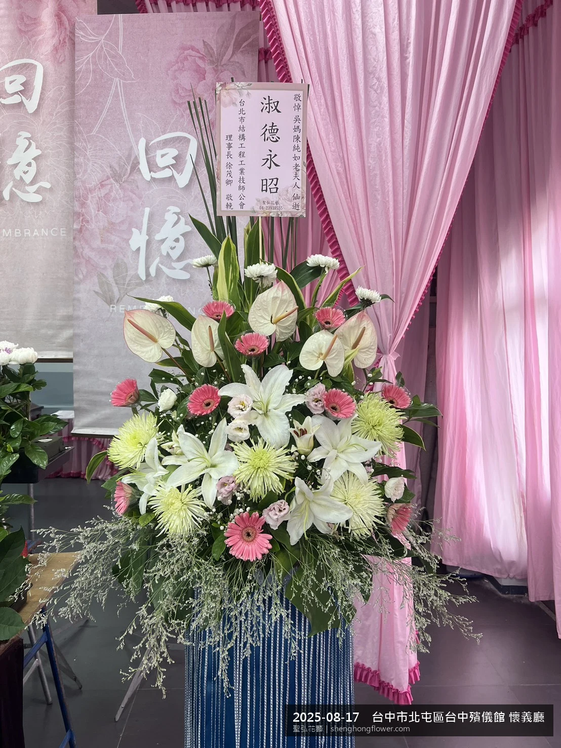 高架白菊花籃主花百合配劍蘭、底部黃菊填充，於夏末暑熱氣候漸轉花朵保鮮極佳。送達台中北屯台中殯儀館 懷義廳前後完成擺設，莊嚴端莊，寄託家屬哀思敬意，聖弘花藝在地團隊現場實拍照。