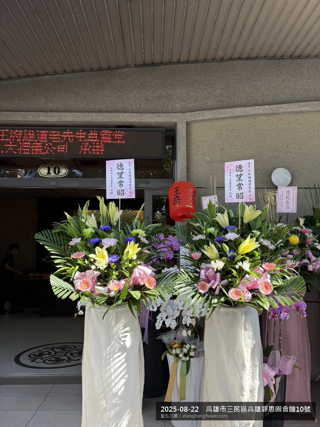 高架白菊花籃主花百合配劍蘭、底部黃菊填充，於夏末暑熱氣候漸轉花朵保鮮極佳。送達高雄三民高雄靜思園會館現場後完成擺設，陳設整齊，於現場完成定位，聖弘花藝在地團隊現場實拍照。