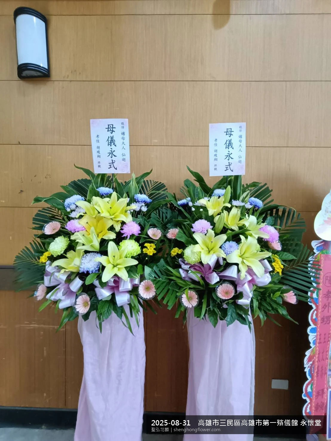 夏末暑熱氣候漸轉下，高雄三民高雄市第一殯儀館 永懷堂前光線柔和。我們選用高架白菊花籃，雙劍蘭挑高、黃菊鋪底，現場顯得配置妥當，依指定方位整齊就位，聖弘花藝在地團隊現場實拍照。
