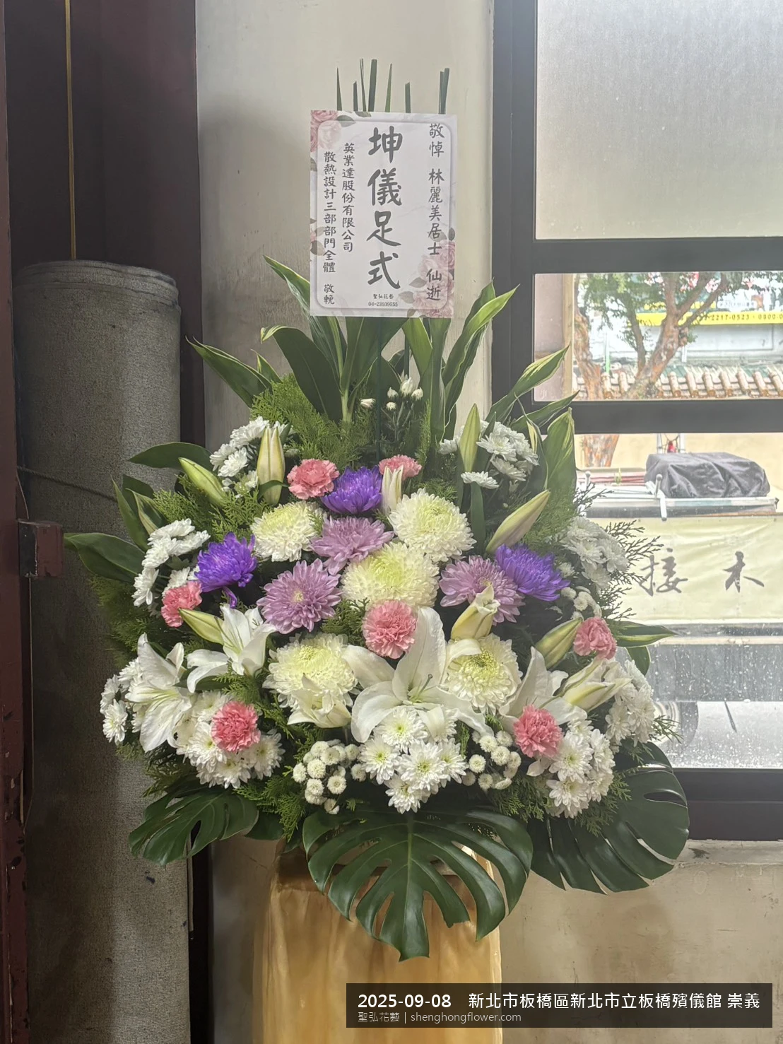 初秋微涼氣候轉爽下，新北板橋新北市立板橋殯儀館 崇義廳前光線柔和。我們選用高架白菊花籃，雙劍蘭挑高、黃菊鋪底，現場顯得配置妥當，依指定方位整齊就位，聖弘花藝在地團隊現場實拍照。