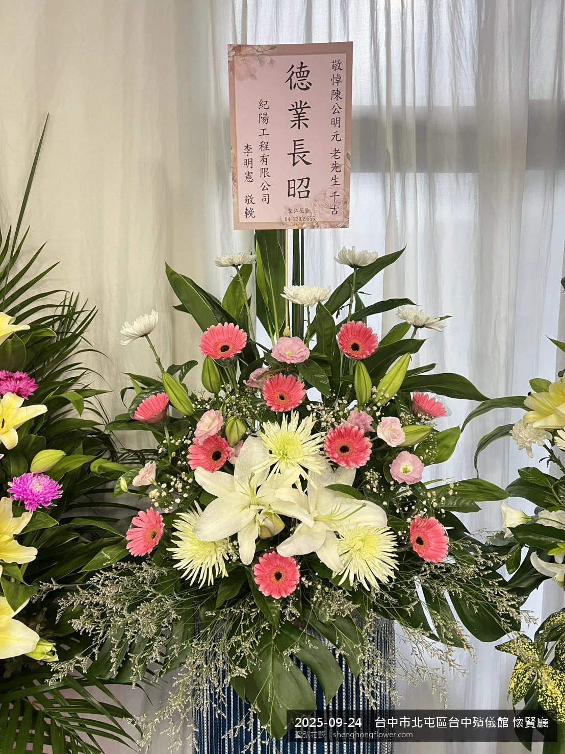 台中北屯台中殯儀館 懷賢廳前置高架白菊花籃，氛圍沉靜典雅。挑高花架穩固、字牌方向清晰，於初秋微涼氣候轉爽就位完成，陪伴家屬度過難捨時刻，聖弘花藝在地團隊現場實拍照。