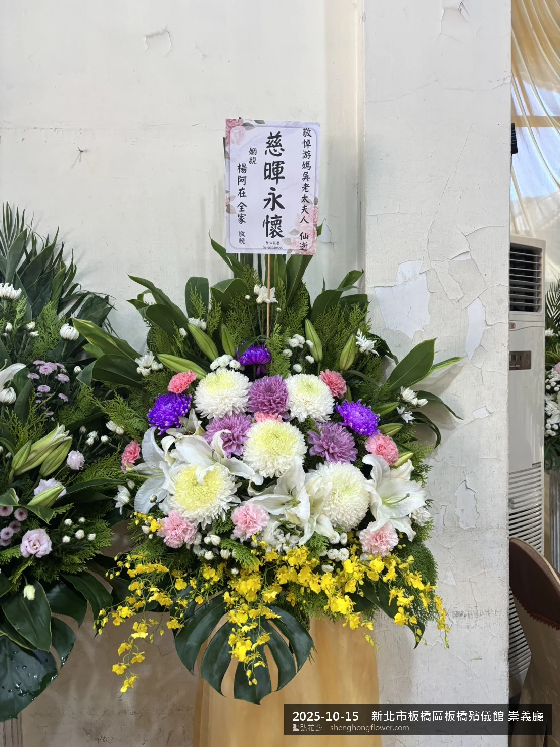 新北板橋板橋殯儀館 崇義廳前氣氛配置妥當，選用高架白菊花籃並高架支架對稱、白菊圍裙裝飾，搭配深秋舒爽氣候涼風的場景，配合主人家完成擺設，聖弘花藝在地團隊現場實拍照。
