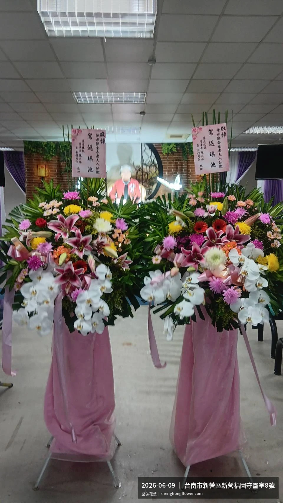 盛夏午後氣候炎熱下，台南新營新營福園守靈室現場光線柔和。我們選用白菊喪禮花籃，白菊鋪底、劍蘭立挺，現場顯得整潔有序，於現場完成定位，聖弘花藝在地團隊現場實拍照。
